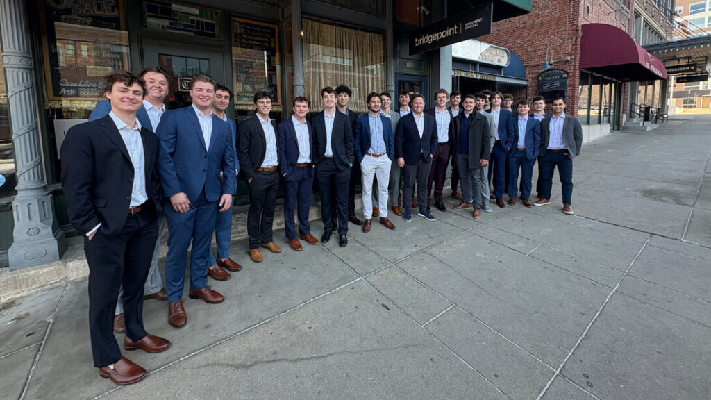 More than a dozen members of Nebraska's Wall Street researchers - a student organization at the University of Nebraska - Lincoln Business College - stand in front of the BridgePoint Investment Banking sign in the center of Lincoln with the firm's CEO, Matt Plooster.